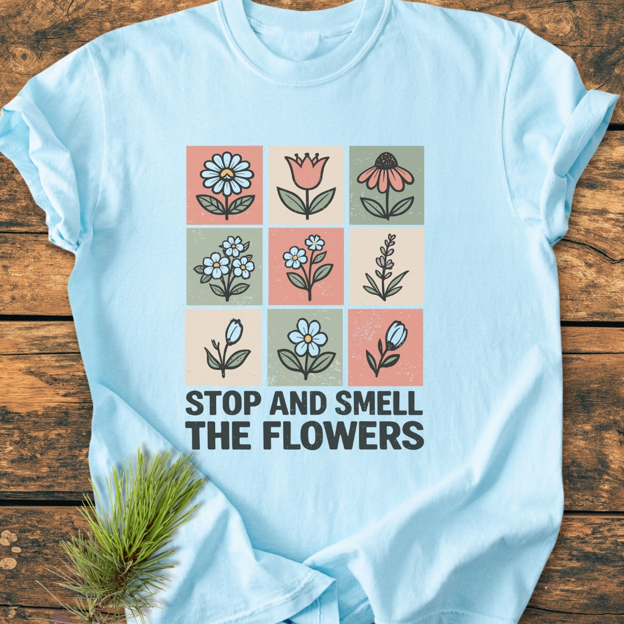 Stop And Smell The Flowers - Vintage Wash Tee features a grid of hand-drawn flowers on a light-blue background with a bold slogan, crafted from soft, durable, 100% ring-spun cotton.