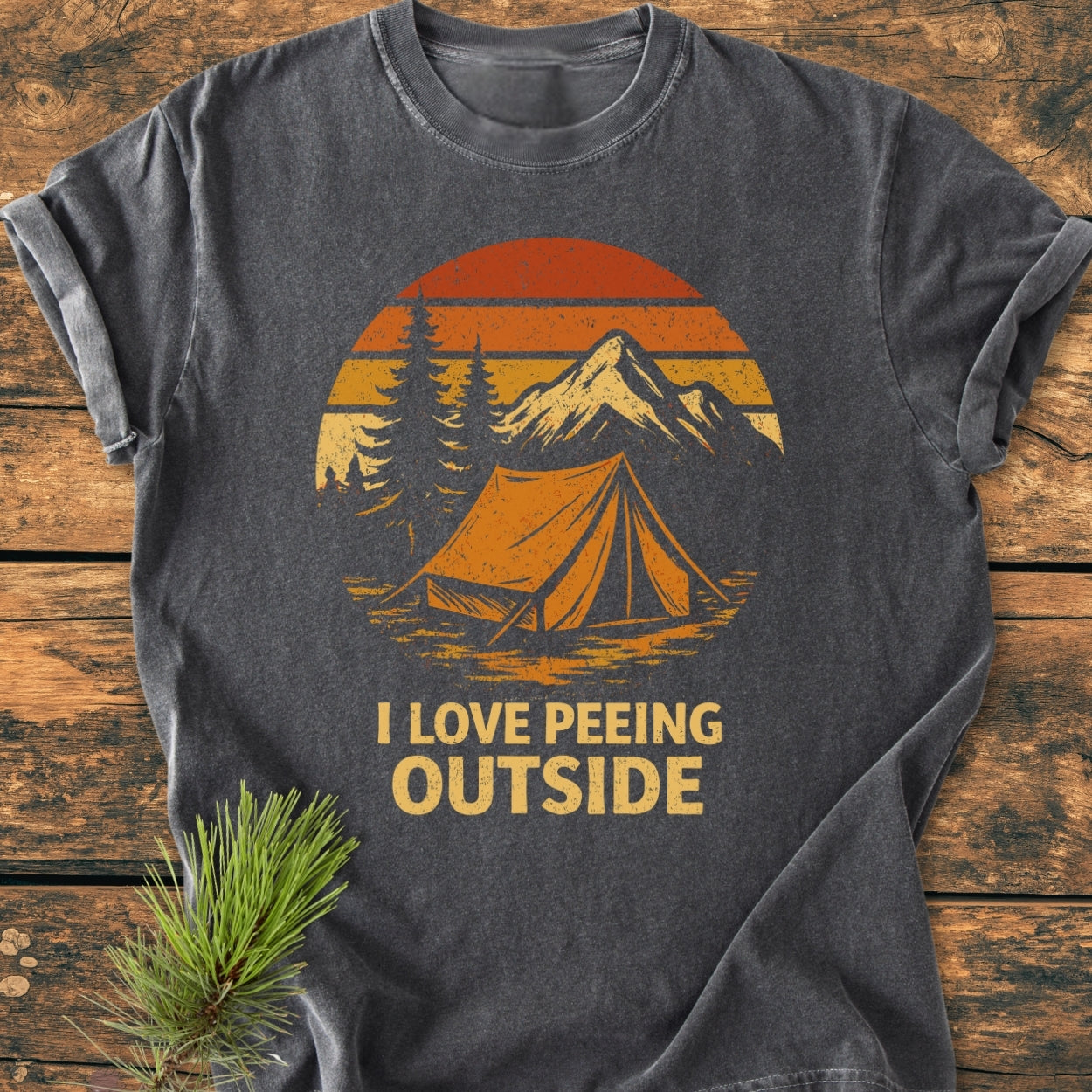 I LOVE Peeing Outside - Vintage Wash Tee: dark-grey, short-sleeve t-shirt with outdoor scene featuring tent, pine trees, mountain, and retro sunset, designed on soft, durable garment-dyed fabric for relaxed daily wear.