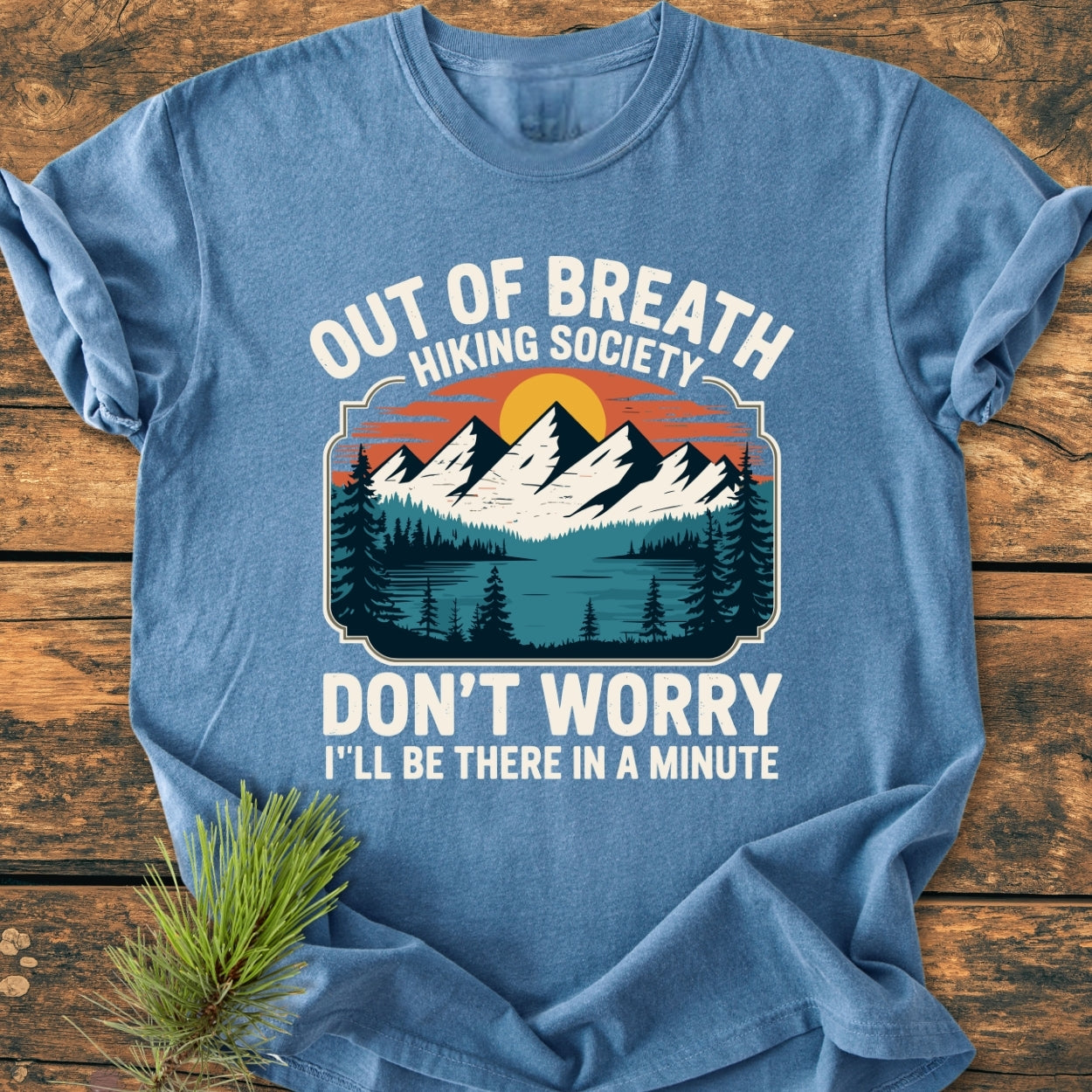 Out Of Breath Hiking Society - Vintage Wash Tee displays a retro hiking graphic with mountains, trees, and sun. Made from soft-washed, 100% ring-spun cotton, offering comfort and durability.