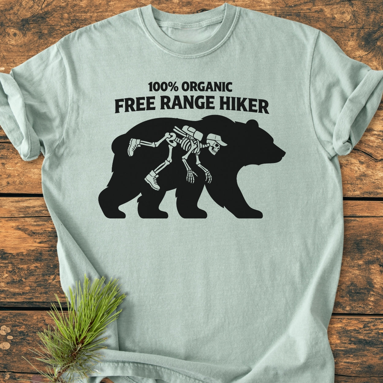Organic Free Range Hiker - Vintage Wash Tee features a playful graphic of a bear with a hiker silhouette. Made from soft, durable 100% ring-spun cotton, offering a relaxed fit and seamless design.