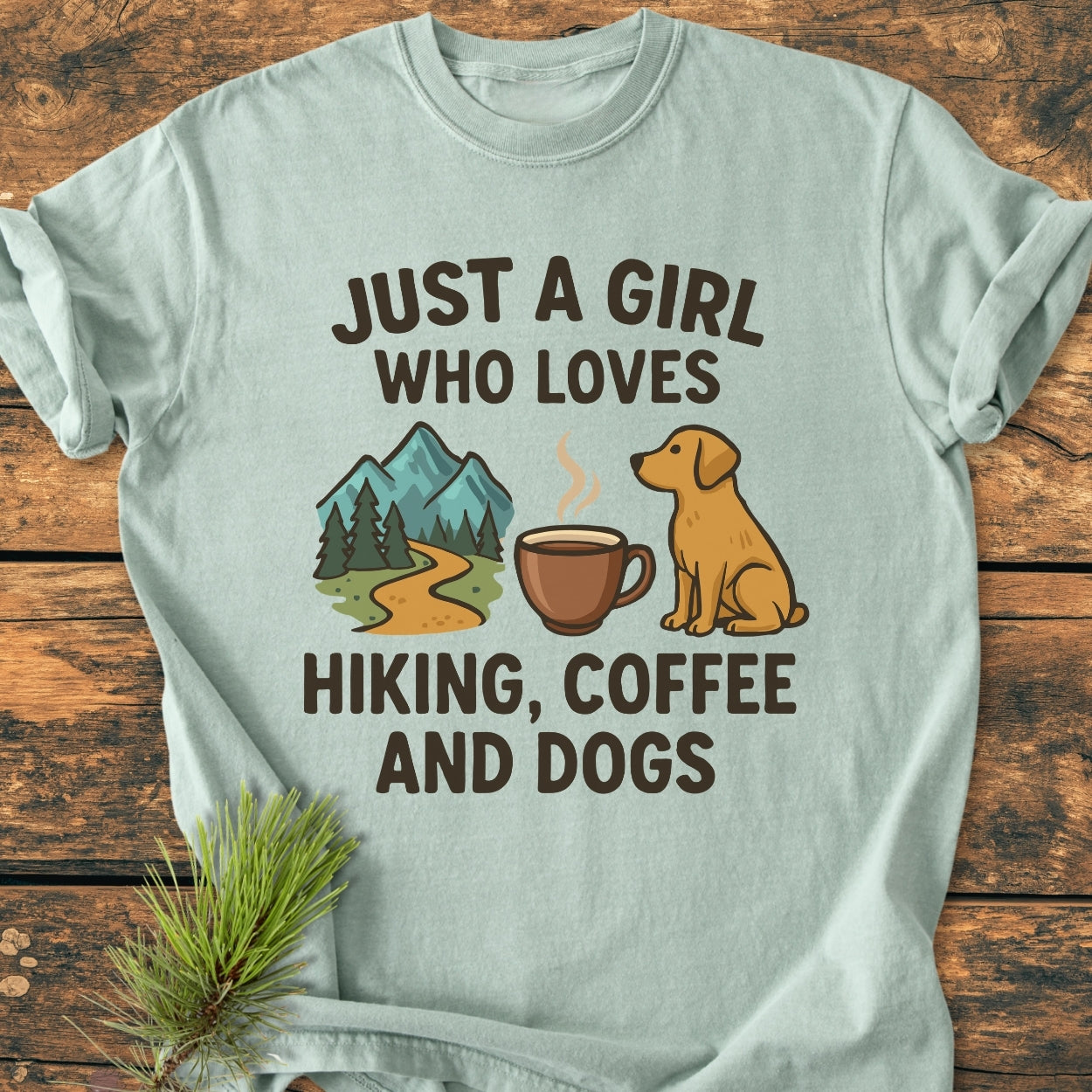 Light-green Just A Girl Who Loves Hiking, Coffee, and Dogs - Vintage Wash Tee with bold lettering and icons of a mountain trail, coffee mug, and dog on front, laying flat.
