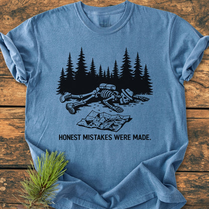 Honest Mistakes Were Made - Vintage Wash Tee featuring a skeleton illustration with “HONEST MISTAKES WERE MADE.” caption, laid on wooden surface, showcasing Comfort Colors' durable, soft-washed, relaxed fit design.
