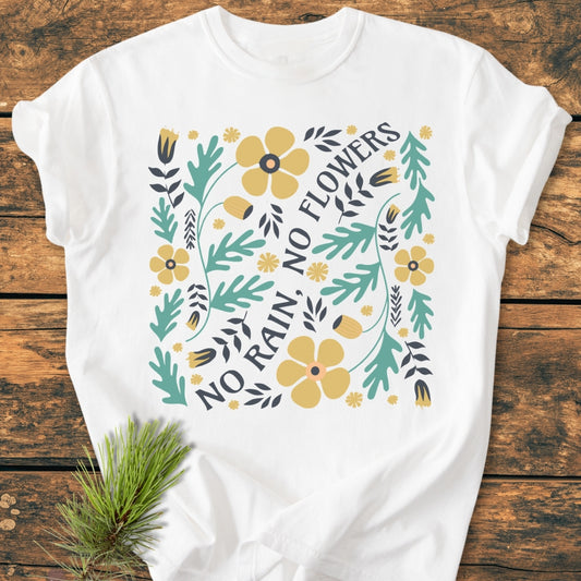 No Rain No Flowers - Vintage Wash Tee features a stylized floral design with yellow blooms and NO RAIN, NO FLOWERS text on a soft, relaxed-fit, white garment-dyed T-shirt, perfect for everyday wear.