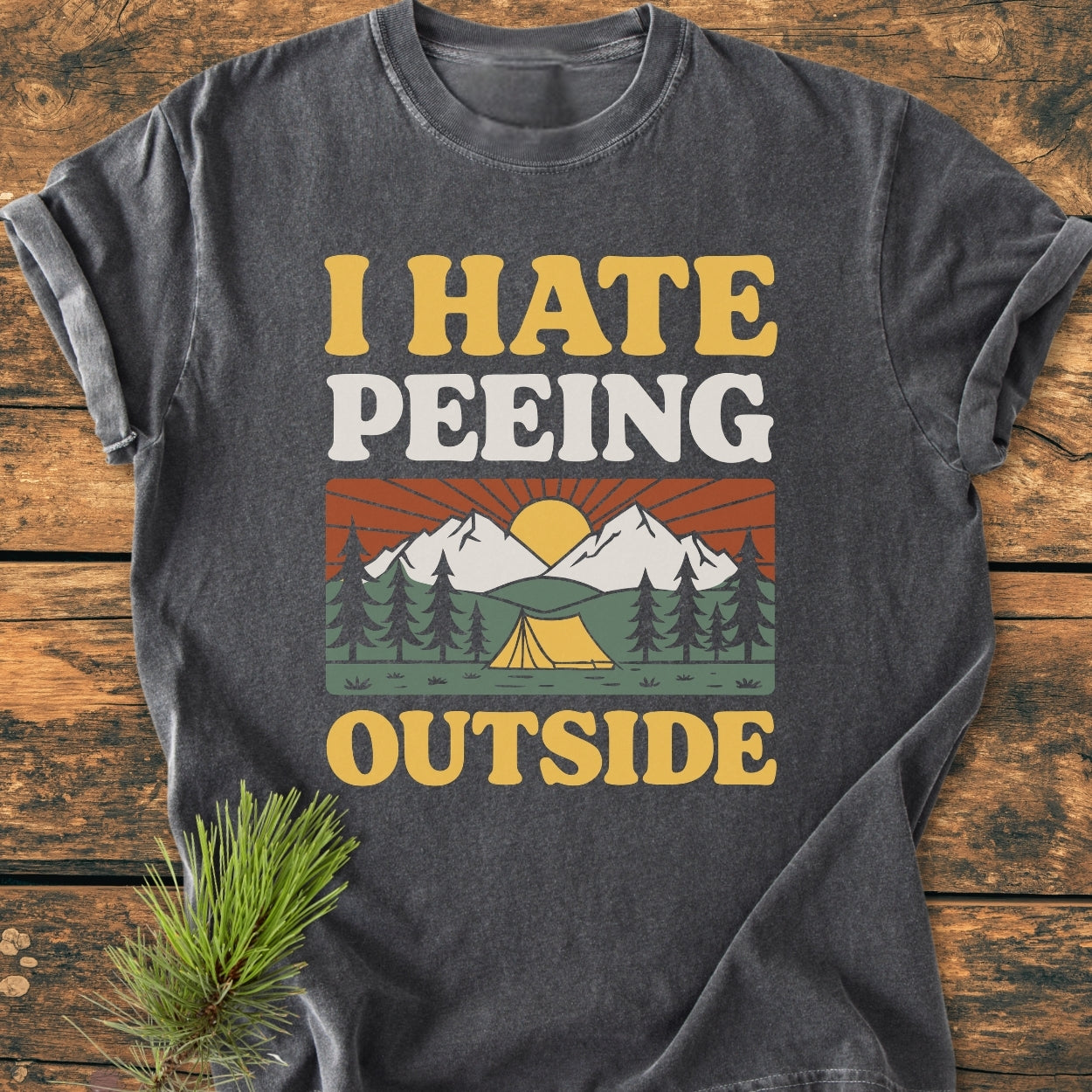 I HATE Peeing Outside - Vintage Wash Tee features a retro campsite graphic with mountains and tent, printed on a dark-gray t-shirt, highlighting comfort with its soft, relaxed, garment-dyed cotton fabric.
