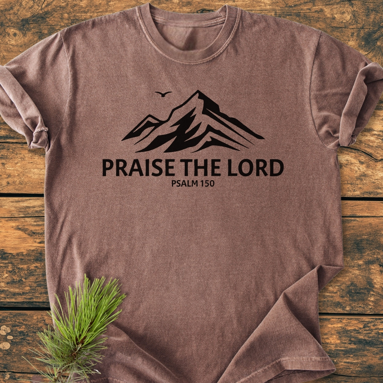 Praise The Lord, Psalm 150 - Vintage Wash Tee featuring a mountain silhouette and bird design, laid flat on wood. Includes garment-dyed, ring-spun cotton for comfort and durability, with a relaxed fit.