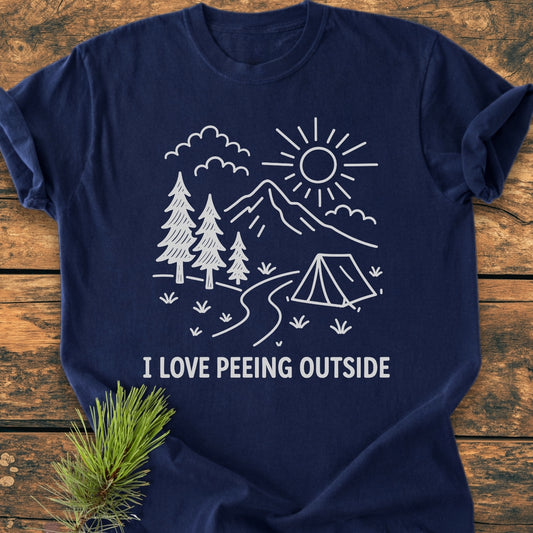 I Love Peeing Outside - Vintage Wash Tee features a white line drawing of an outdoor scene on a navy-blue T-shirt, adding a quirky, nature-loving vibe to this soft, relaxed-fit garment.