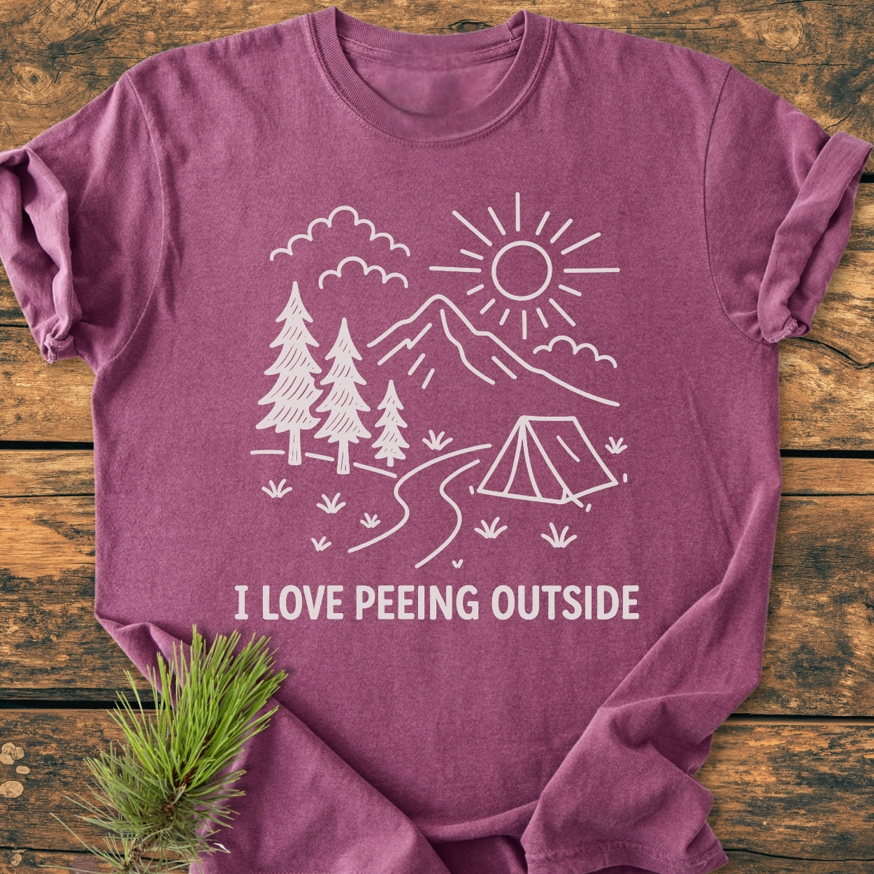The I Love Peeing Outside - Vintage Wash Tee features a white line-drawing of nature with trees and mountains, plus humorous text, on a soft, relaxed-fit T-shirt.