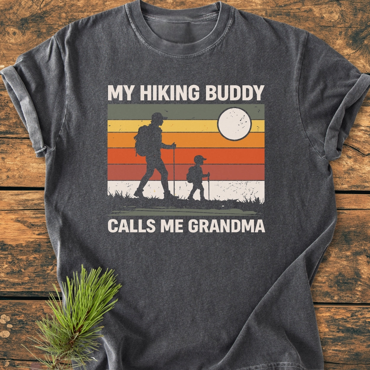 My Hiking Buddy Calls Me Grandma - Vintage Wash Tee features a retro graphic of two hikers on a soft dark-gray T-shirt, showcasing durable, relaxed fit with garment-dyed, ring-spun cotton.