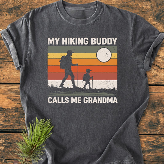 My Hiking Buddy Calls Me Grandma - Vintage Wash Tee features a retro graphic of two hikers on a soft dark-gray T-shirt, showcasing durable, relaxed fit with garment-dyed, ring-spun cotton.