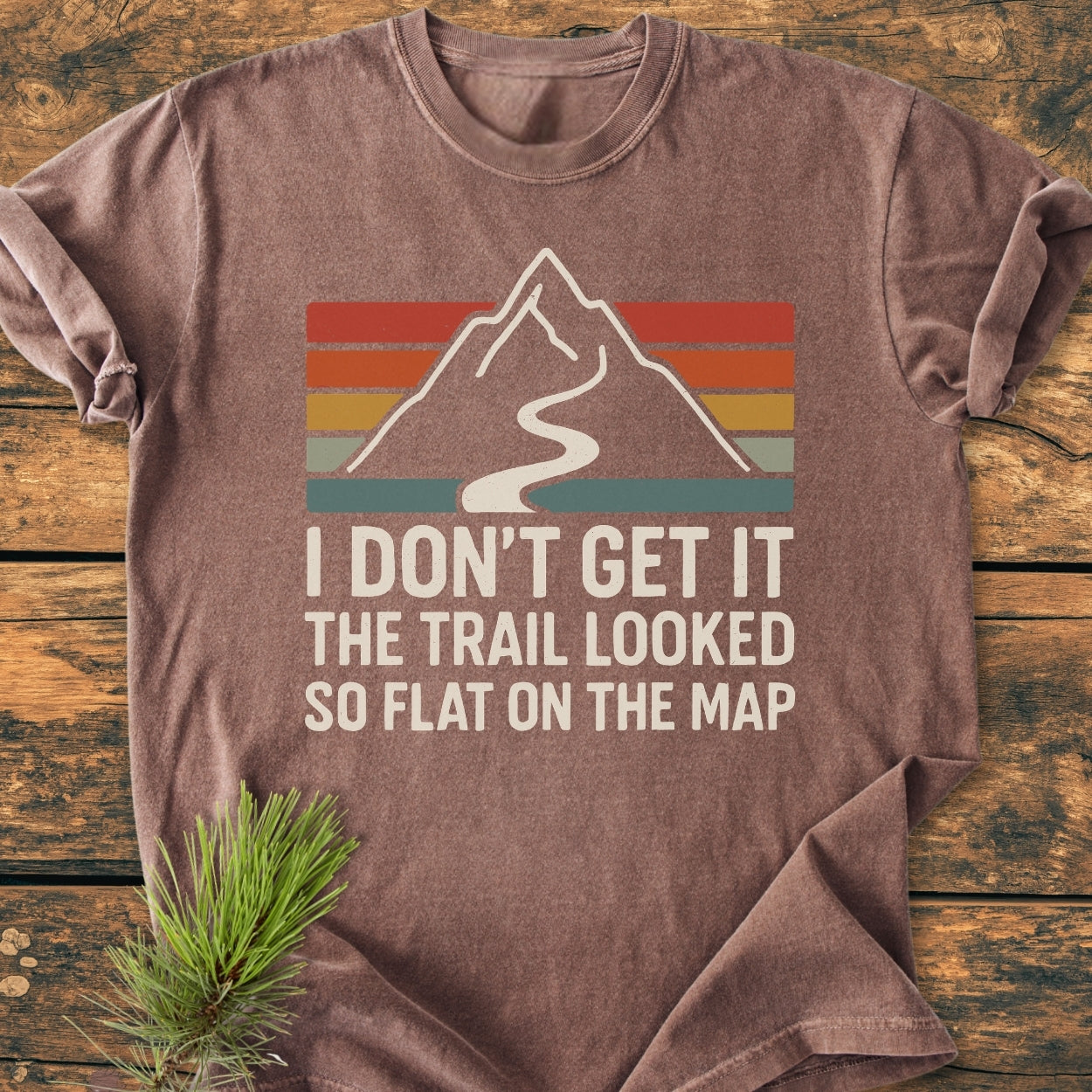 I Don't Get It - Vintage Wash Tee features a mountain graphic with retro stripes and a humorous slogan, laid flat. Made with soft-washed, garment-dyed cotton for comfort and durability.
