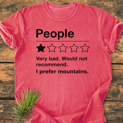 I Prefer Mountains - Vintage Wash Tee displayed on wood, featuring a humorous mock review design, relaxed fit, and durable stitching. Made from pre-shrunk, soft-washed 100% ring-spun cotton.