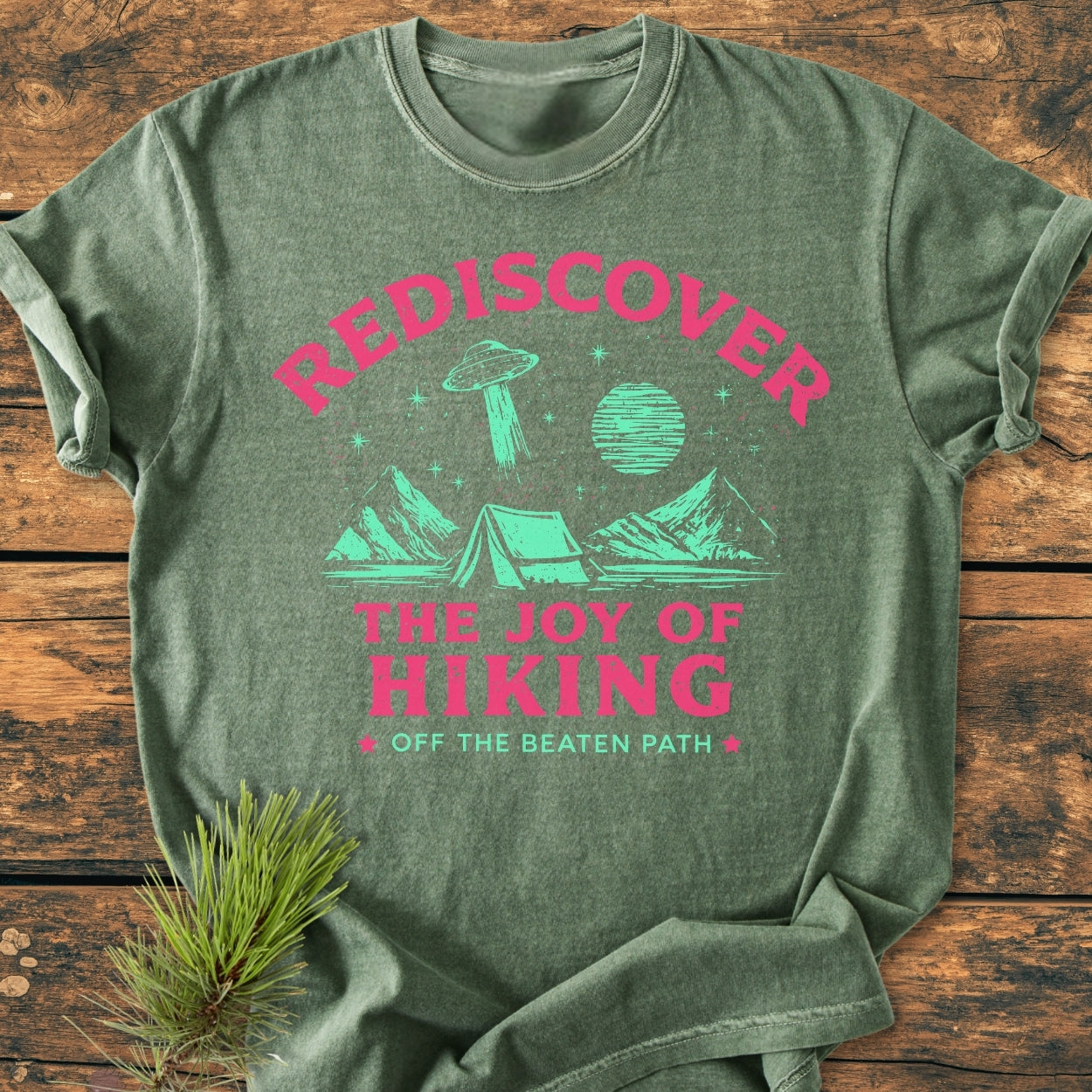 Rediscover The Joy Of Hiking - Vintage Wash Tee features a retro outdoorsy design with a tent, mountains, stars, a UFO, and bold lettering on an olive-green Comfort Colors garment-dyed T-shirt.