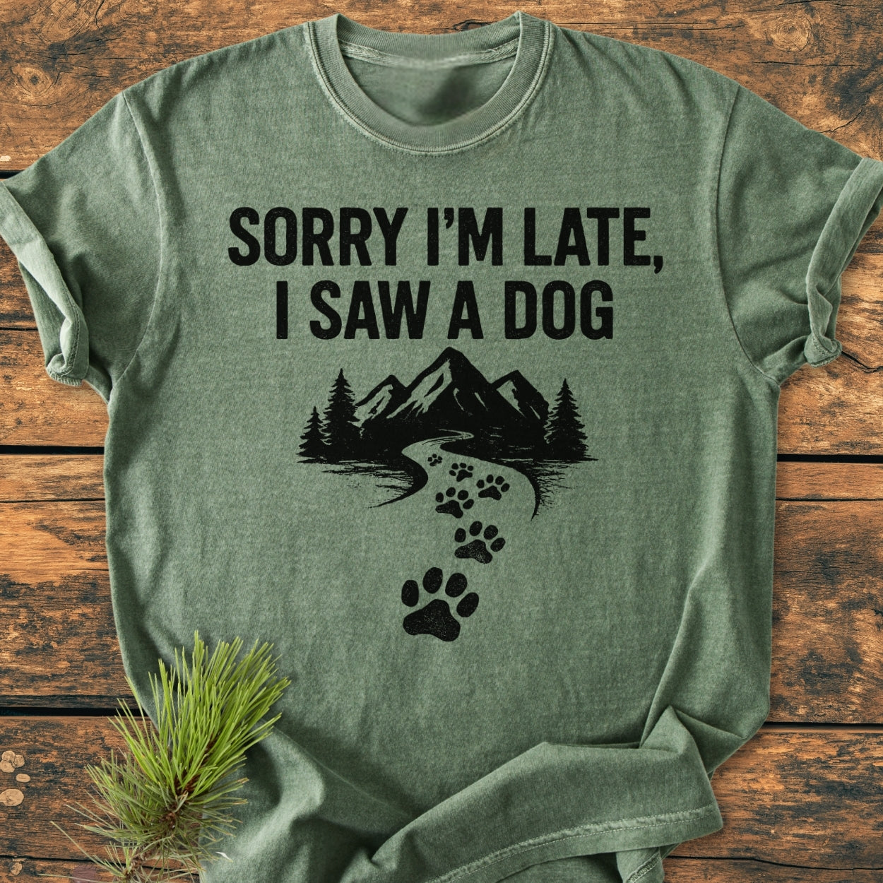Sorry I'm Late - Vintage Wash Tee featuring a black graphic with SORRY I'M LATE, I SAW A DOG text, mountain-and-forest scene, and paw prints on a soft, short-sleeve, ring-spun cotton T-shirt.