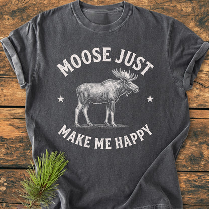 Moose Make Me Happy - Vintage Wash Tee features a white moose line-drawing with stars on a charcoal tee, sleeves rolled, laid flat on wood. Cozy, relaxed fit, crafted from 100% ring-spun cotton.