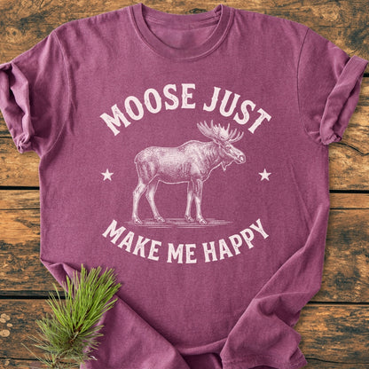 Moose Make Me Happy - Vintage Wash Tee: Heather-purple T-shirt featuring a moose line-drawing with stars, folded on wood. Includes MOOSE JUST MAKE ME HAPPY text. Pine sprig beside enhances rustic charm.