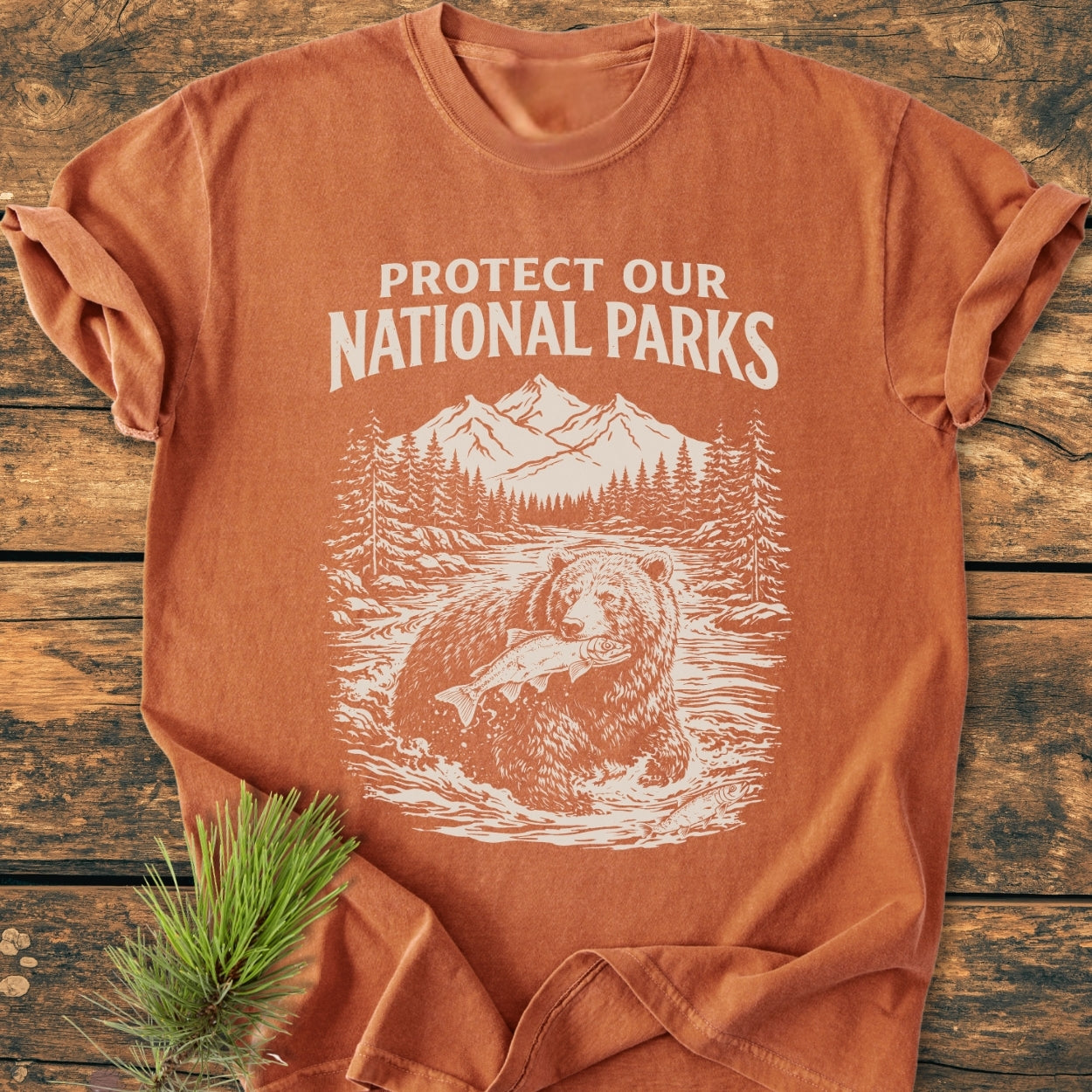 Protect Our National Parks - Vintage Wash Tee features a nature-themed design with a bear, river, and mountains. Made from soft, garment-dyed cotton, it offers a relaxed fit and durable construction.