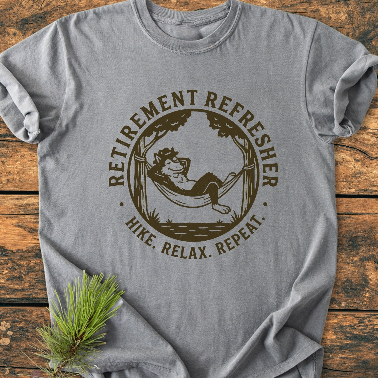 Retirement: Hike. Relax. Repeat - Vintage Wash Tee features a heather-gray garment with a fox hammock graphic, showcasing RETIREMENT REFRESHER and HIKE. RELAX. REPEAT. text, styled with a pine sprig.