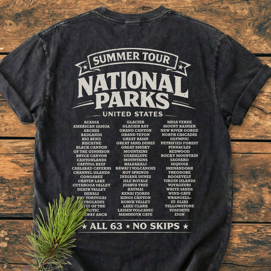 Summer Tour National Parks BACK PRINT - Vintage Wash Tee featuring all 63 U.S. National Parks in white ink on the back, laid on a wooden surface with a pine sprig.