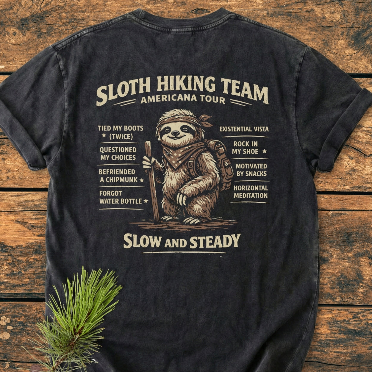 Sloth Hiking Team Tour BACK PRINT - Vintage Wash Tee features a whimsical sloth with a bandana and hiking gear, surrounded by a playful checklist, on a soft, durable garment-dyed T-shirt.