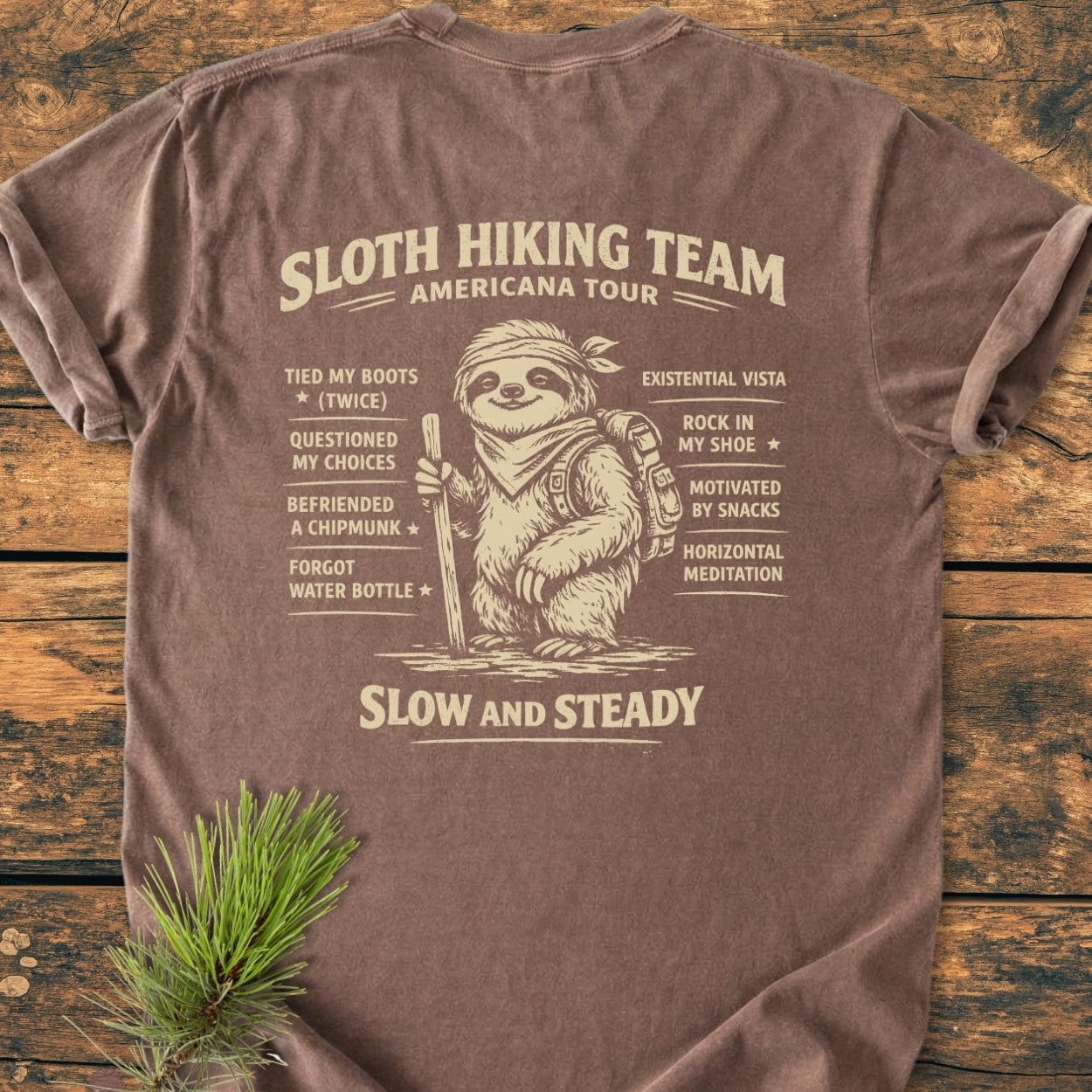 Sloth Hiking Team Tour BACK PRINT - Vintage Wash Tee features a cartoon sloth with hiking gear and a humorous checklist on a soft, relaxed-fit, 100% ring-spun cotton brown T-shirt.