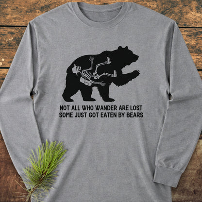 Mistakes Were Made Long-Sleeve Tee featuring a bear silhouette with a skeleton inside, captioned humorously about wandering and bears. Laid flat on wood with a pine sprig, showcasing its casual style.