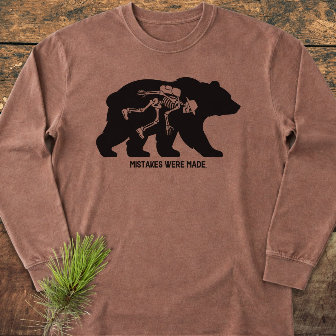 Mistakes Were Made Long-Sleeve Tee features a black bear silhouette with a skeleton inside, paired with the caption MISTAKES WERE MADE. Crafted from 100% ring-spun cotton for a comfortable, relaxed fit.