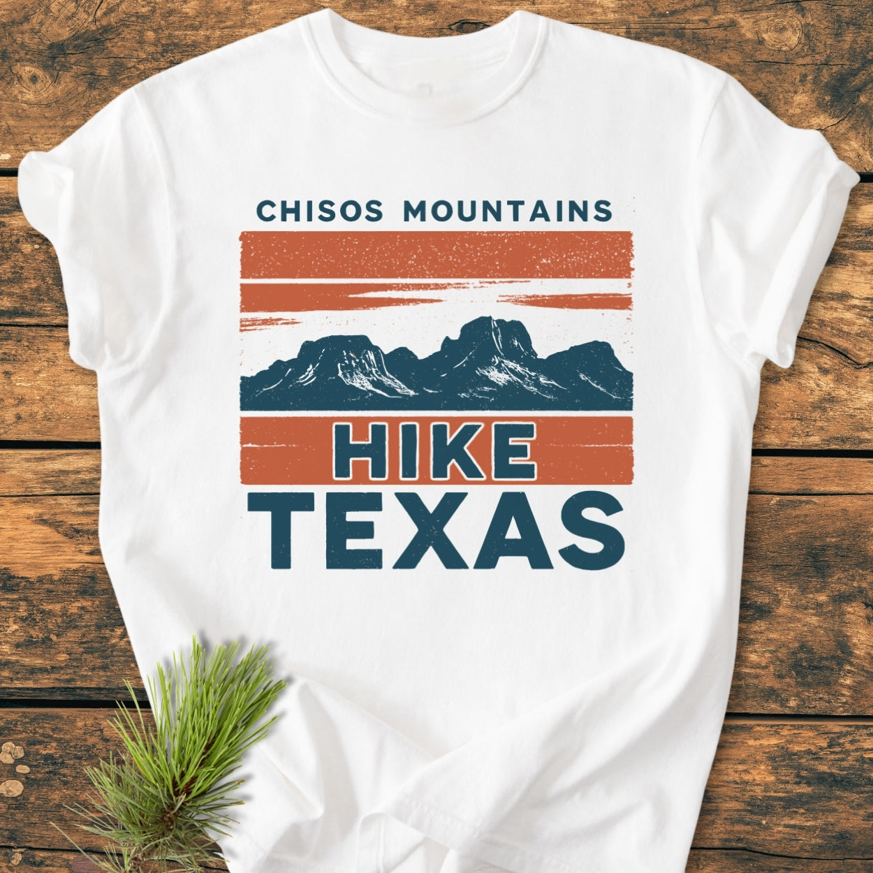 Chisos Mountains Texas - Vintage Wash Tee featuring a mountain graphic and bold “HIKE TEXAS” text, displayed on wood with a pine sprig accent. Made from soft, garment-dyed, 100% ring-spun cotton.