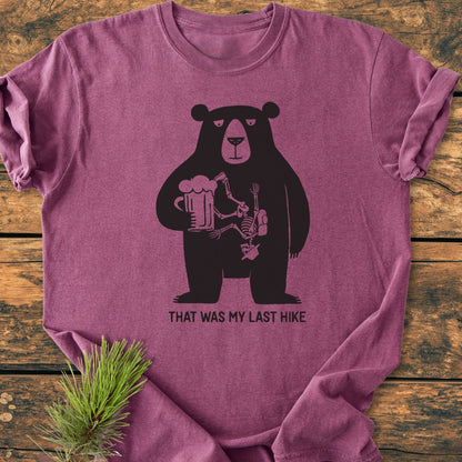 That Was My Last Hike - Vintage Wash Tee features a bear silhouette with a skeleton inside, holding a beer mug, captioned humorously. Laid flat, highlighting its soft, relaxed fit and durable construction.