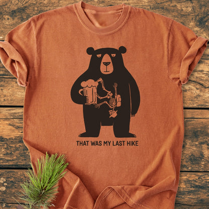 That Was My Last Hike - Vintage Wash Tee: Rust-orange T-shirt featuring a black bear with a beer mug and hiker bones design, captioned humorously. Cozy, relaxed fit, durable, made from 100% ring-spun cotton.