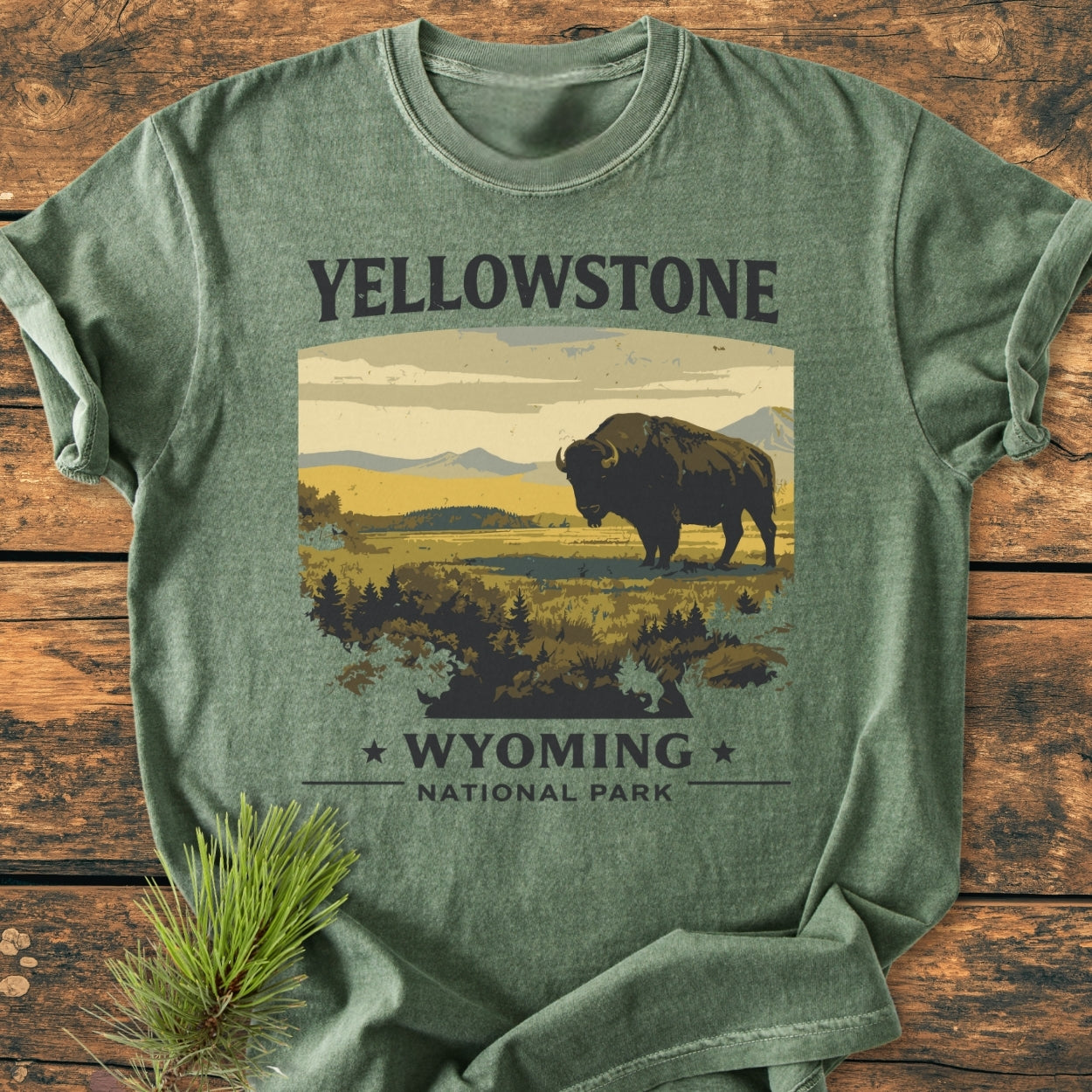 Yellowstone - Vintage Wash Tee features a stylized bison scene with YELLOWSTONE text, laid on rustic wood. Crafted from soft, durable 100% ring-spun cotton, perfect for everyday comfort.