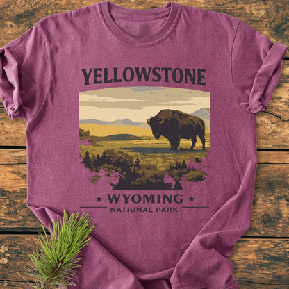 Yellowstone - Vintage Wash Tee featuring a bison silhouette against mountains, printed on a maroon heather shirt, laid on wood, with a pine sprig nearby, embodying cozy, relaxed fit and durable design.