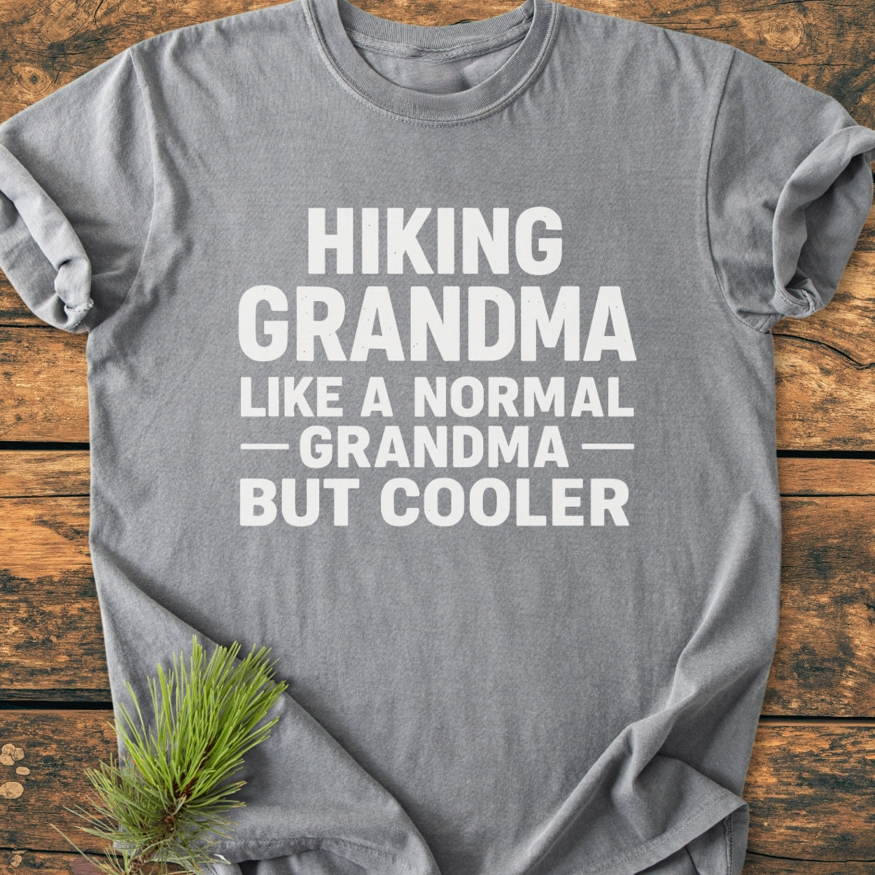 Hiking Grandma - Vintage Wash Tee displayed flat, showcasing a bold slogan in white block letters. The soft, relaxed fit highlights its cozy appeal, ideal for those seeking comfort and style.