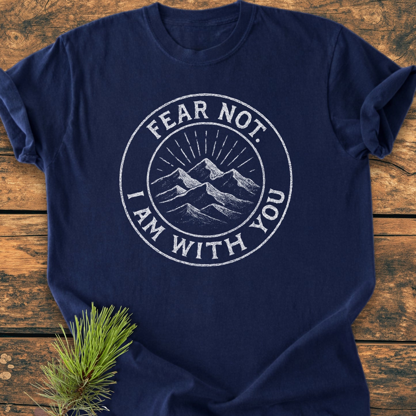 Fear Not - Vintage Wash Tee on wooden surface, displaying mountain badge graphic with “FEAR NOT. I AM WITH YOU.” Pine sprig accents this soft, relaxed-fit, navy-blue Comfort Colors garment-dyed shirt.