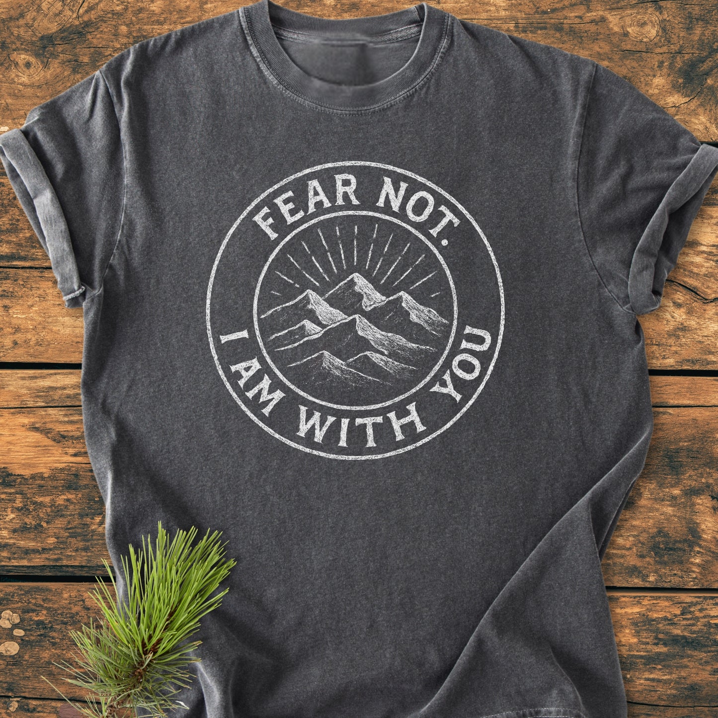 Fear Not - Vintage Wash Tee in charcoal-gray, featuring a white, stamp-style mountain graphic and message FEAR NOT. I AM WITH YOU, laid flat with pine sprig accent.