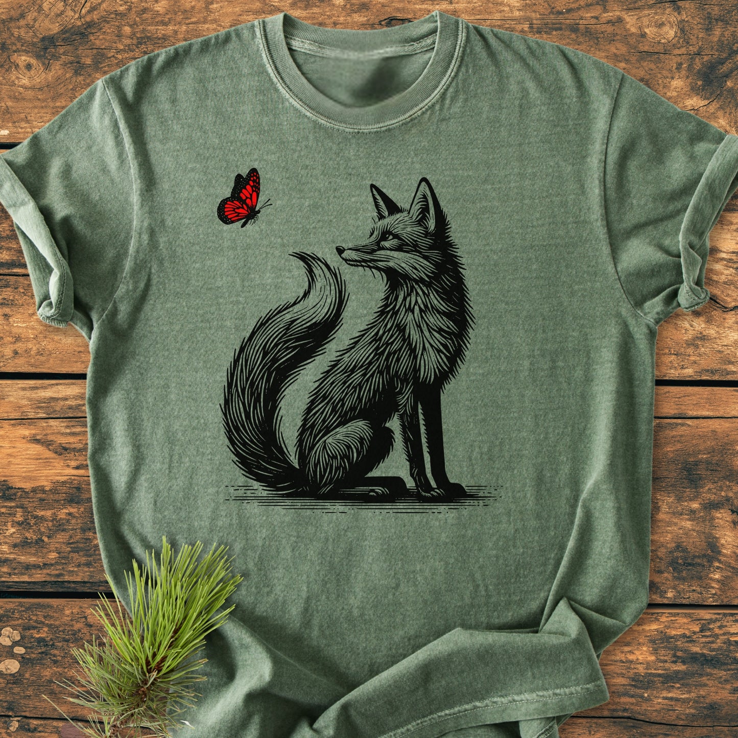 Fox And Butterfly - Vintage Wash Tee features a green heathered T-shirt with a black line-art fox and red butterfly illustration, laid flat, emphasizing its cozy, relaxed fit and durable craftsmanship.