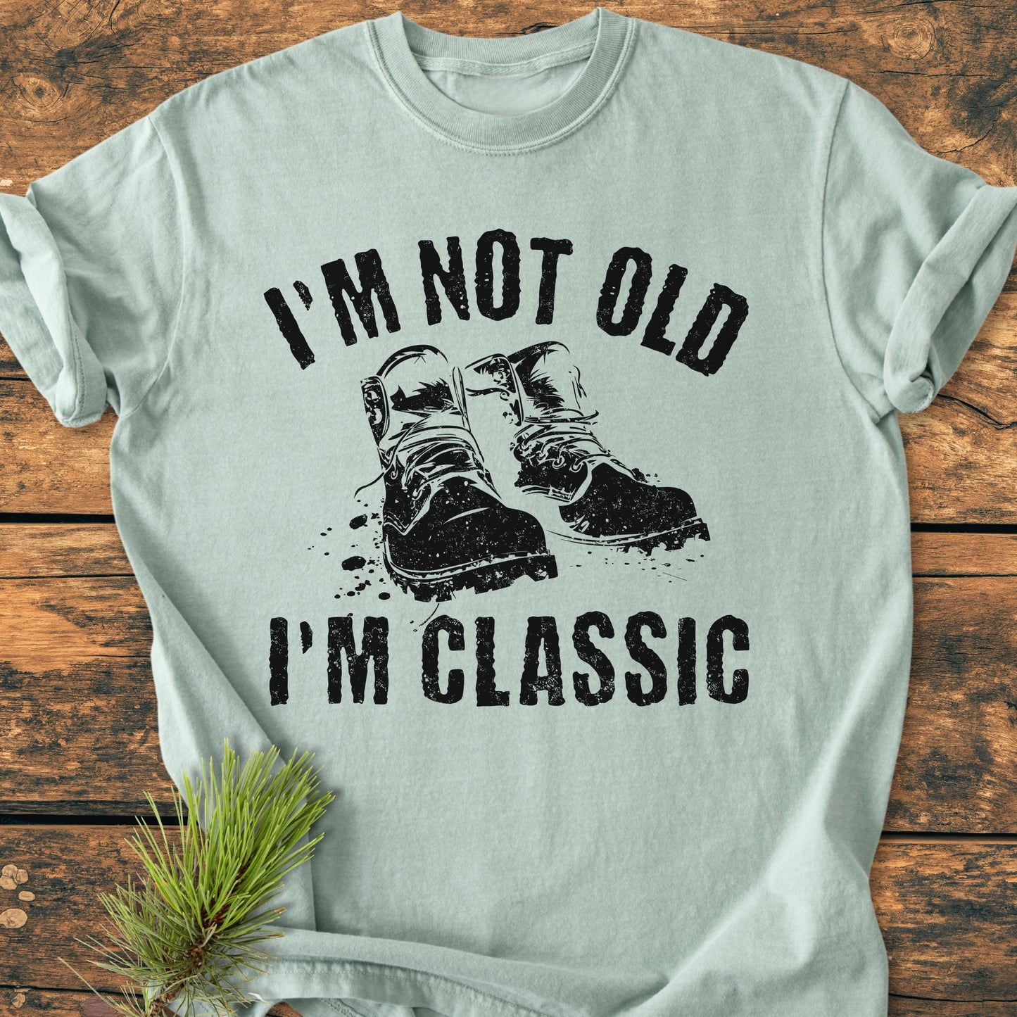 I'm Not Old I'm Classic - Vintage Wash Tee features a distressed graphic of boots and slogan on a soft, relaxed-fit light-green T-shirt, highlighting durable craftsmanship and comfort.