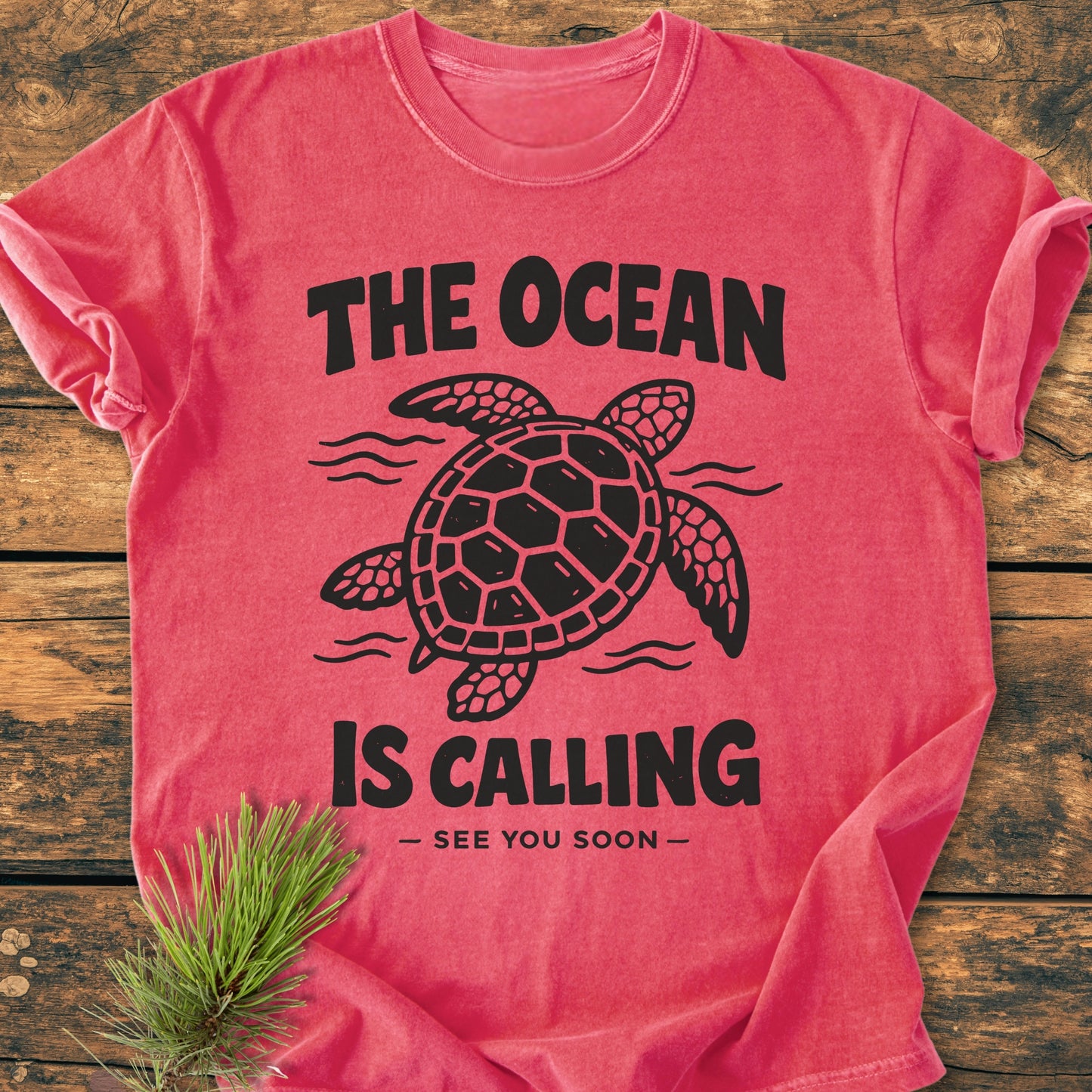 The Ocean Is Calling - Vintage Wash Tee displays a stylized sea turtle with wavy lines, adorned with the phrases THE OCEAN IS CALLING and — SEE YOU SOON — on soft-washed fabric.