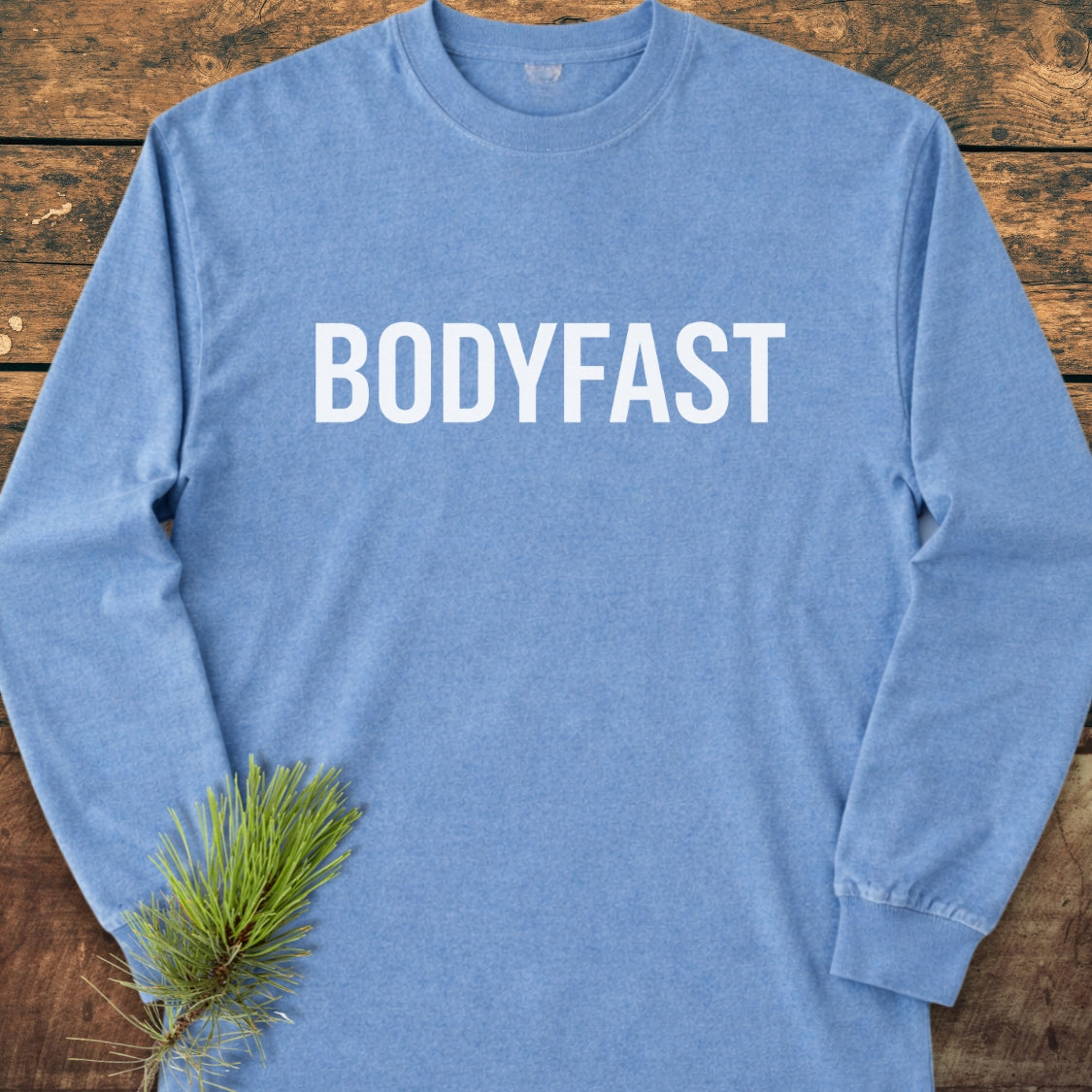 BODYFAST Long-Sleeve Tee in light blue, laid flat, featuring bold white lettering across the chest; crafted from 100% ring-spun cotton for a soft, relaxed fit.