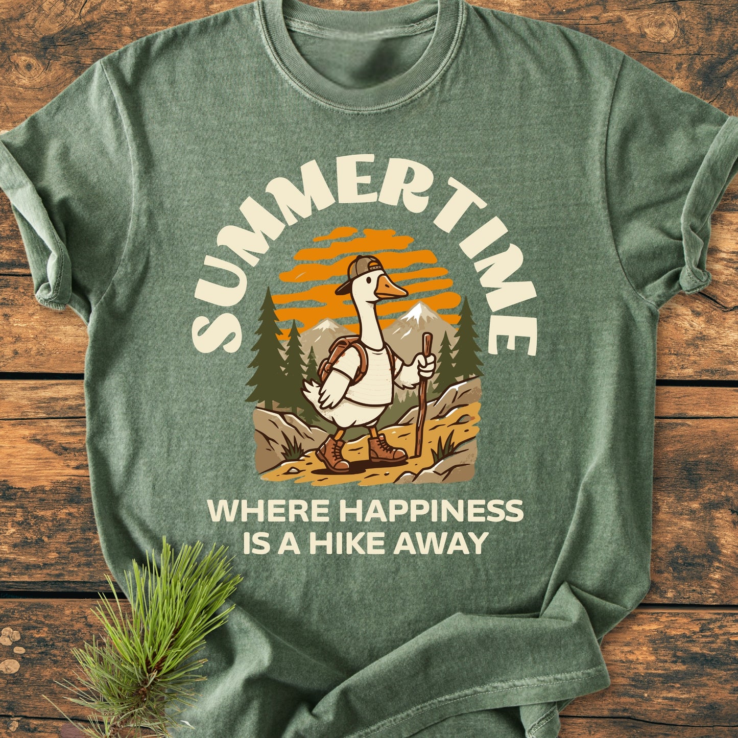 Summertime Hike - Vintage Wash Tee features a cartoon goose trekking through a mountain scene, adding charm to this soft, garment-dyed t-shirt, perfect for comfort and durability.