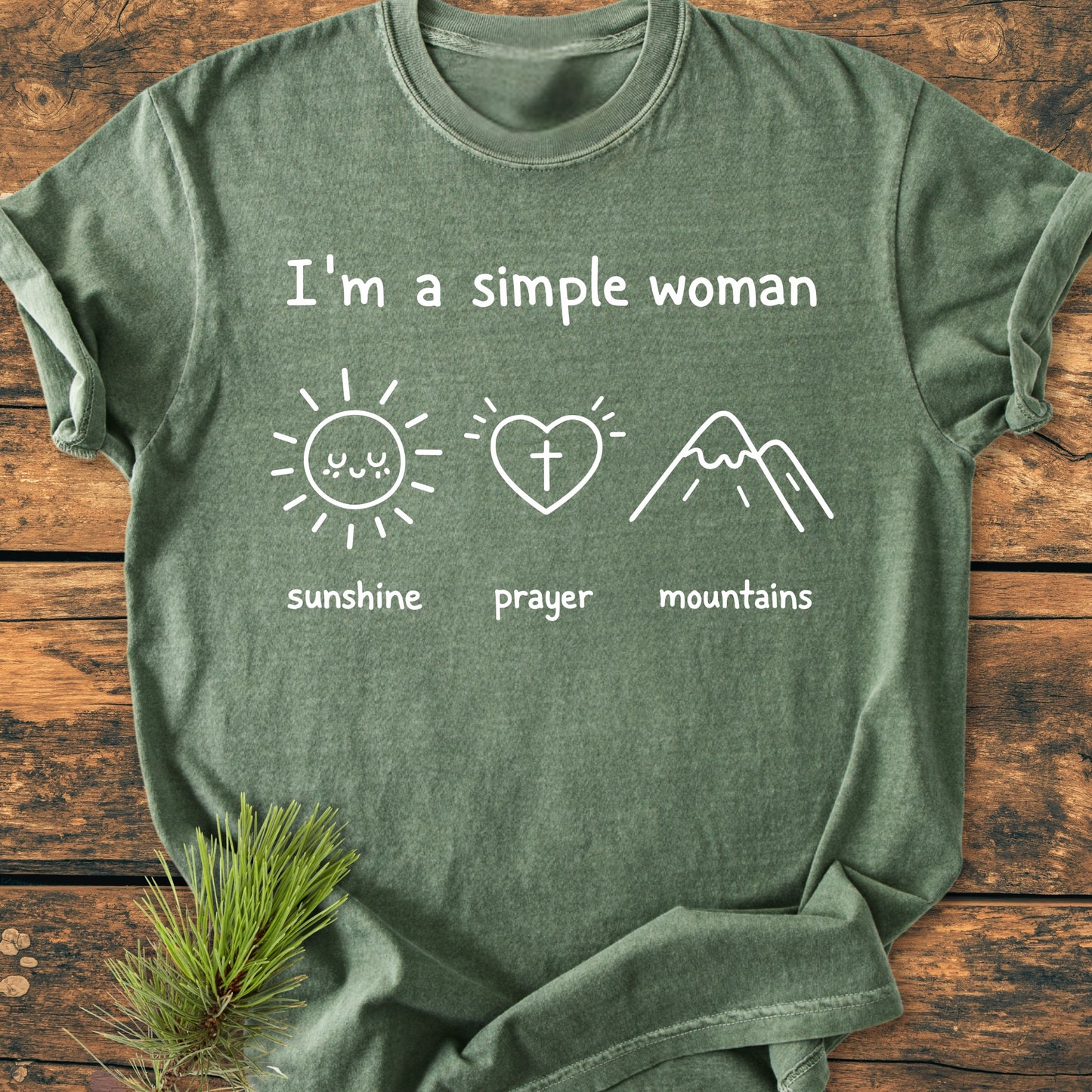 I'm A Simple Woman - Sunshine Prayer Mountains - Vintage Wash Tee on rustic wood, featuring white text and icons of a sun, heart with cross, and mountains, emphasizing comfort with ring-spun cotton.