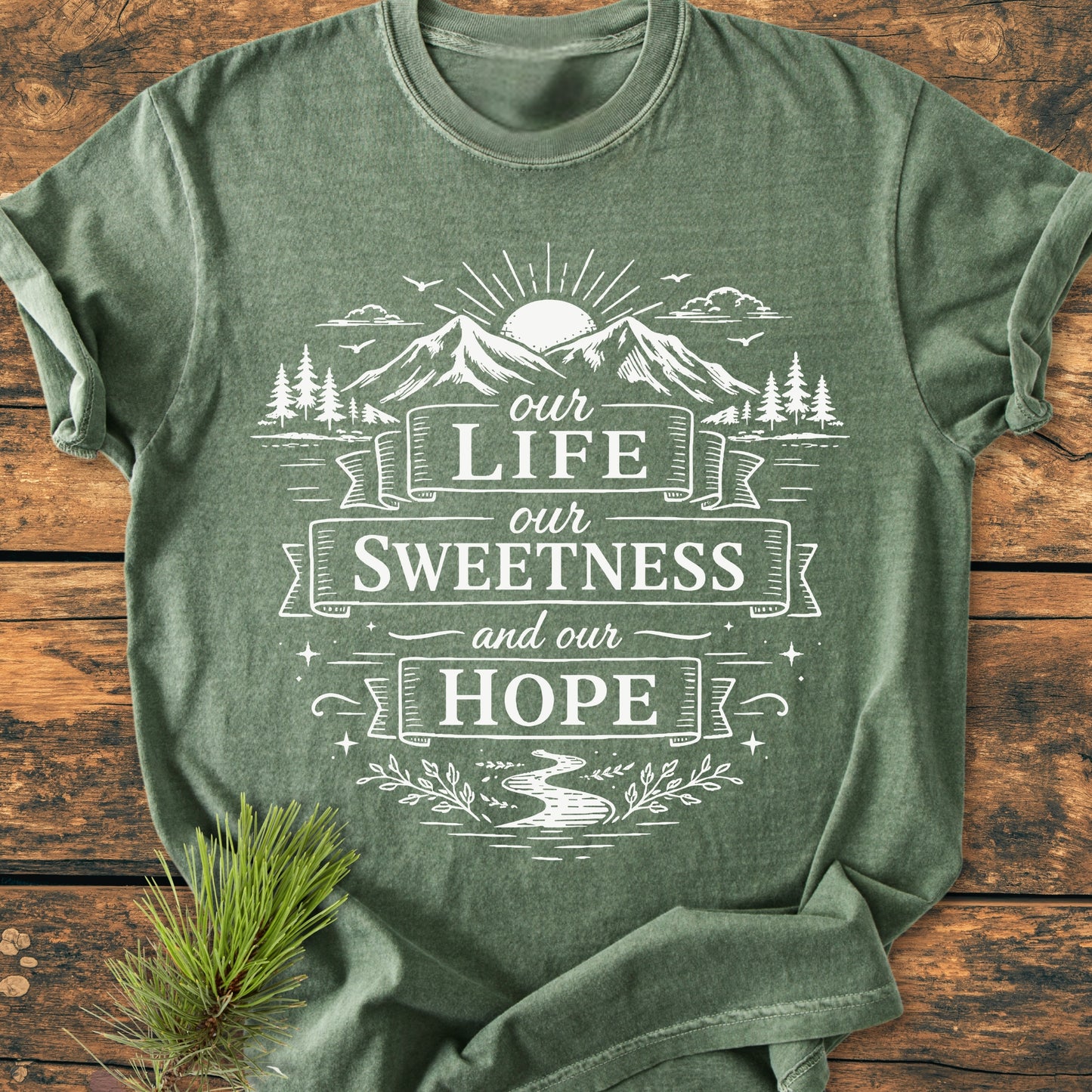 Our Life, Our Sweetness, Our Hope - Vintage Wash Tee featuring a nature-themed design with a sun, mountains, and river, screen-printed in white on a forest-green Comfort Colors T-shirt.