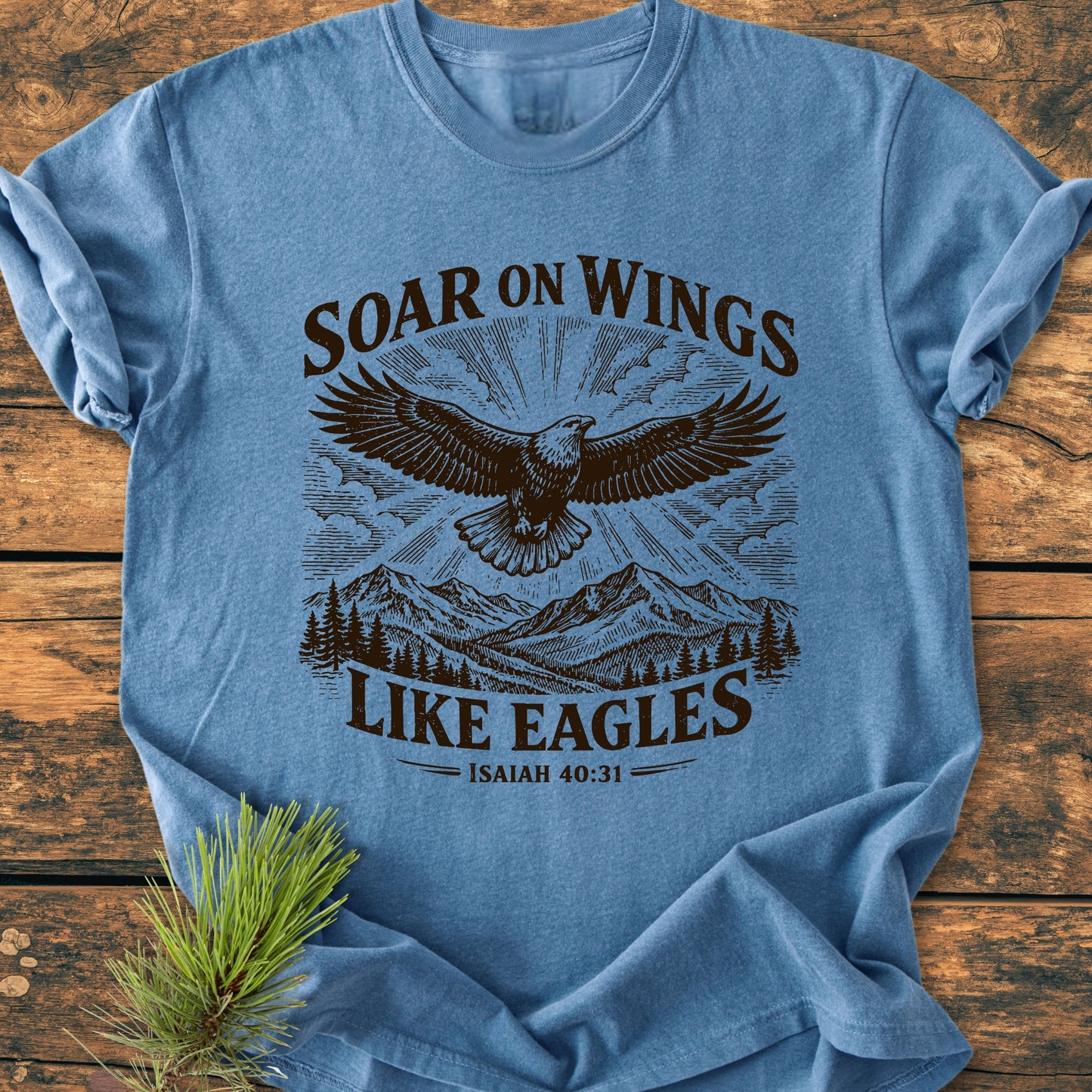 Soar On Wings Like Eagles Isaiah 40:31 - Vintage Wash Tee featuring an eagle design with mountains and trees. Made of 100% ring-spun cotton, it offers a relaxed fit and durable stitching.