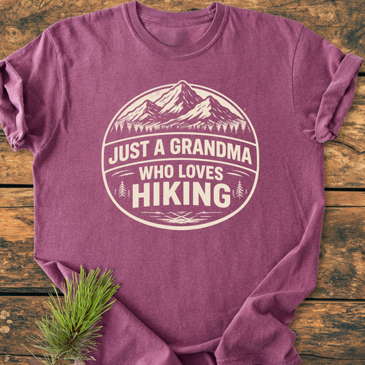 Just A Grandma Who Loves Hiking - Vintage Wash Tee features a mountain and pine tree badge on soft, heathered fabric, ideal for comfort and durability with its relaxed fit and ring-spun cotton.