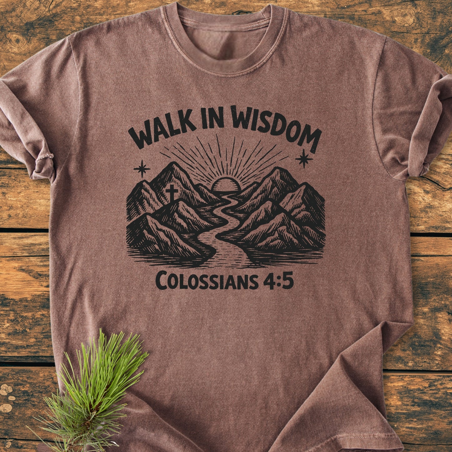 Walk In Wisdom, Colossians 4:5 - Vintage Wash Tee features a mountain-and-river sunrise graphic with sunrays, a cross, and stars, styled on a soft, brown heather t-shirt.