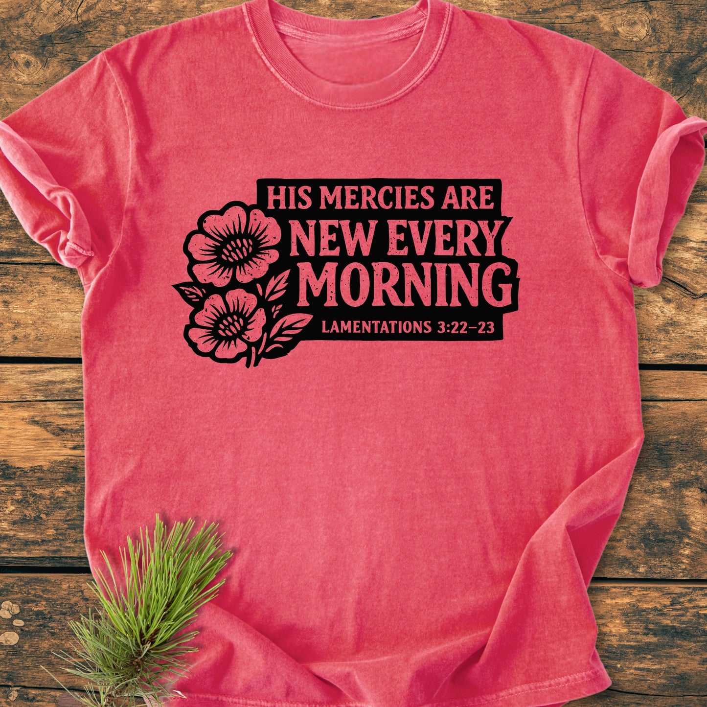 New Every Morning Lamentations 3:22-23 - Vintage Wash Tee features bold black floral graphics on a heathered-pink background, accompanied by pine needles, highlighting its rustic appeal and relaxed fit.