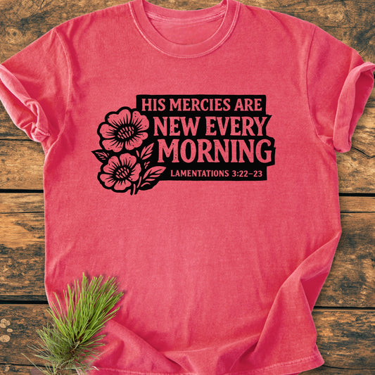 New Every Morning Lamentations 3:22-23 - Vintage Wash Tee features bold black floral graphics on a heathered-pink background, accompanied by pine needles, highlighting its rustic appeal and relaxed fit.