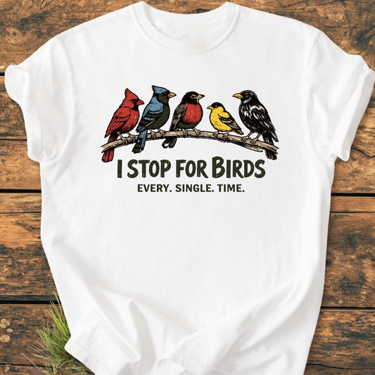 I Stop For Birds - Vintage Wash Tee featuring five songbirds and slogan on a white T-shirt, laid on a wooden surface. Made from 100% ring-spun cotton, offering a relaxed fit.