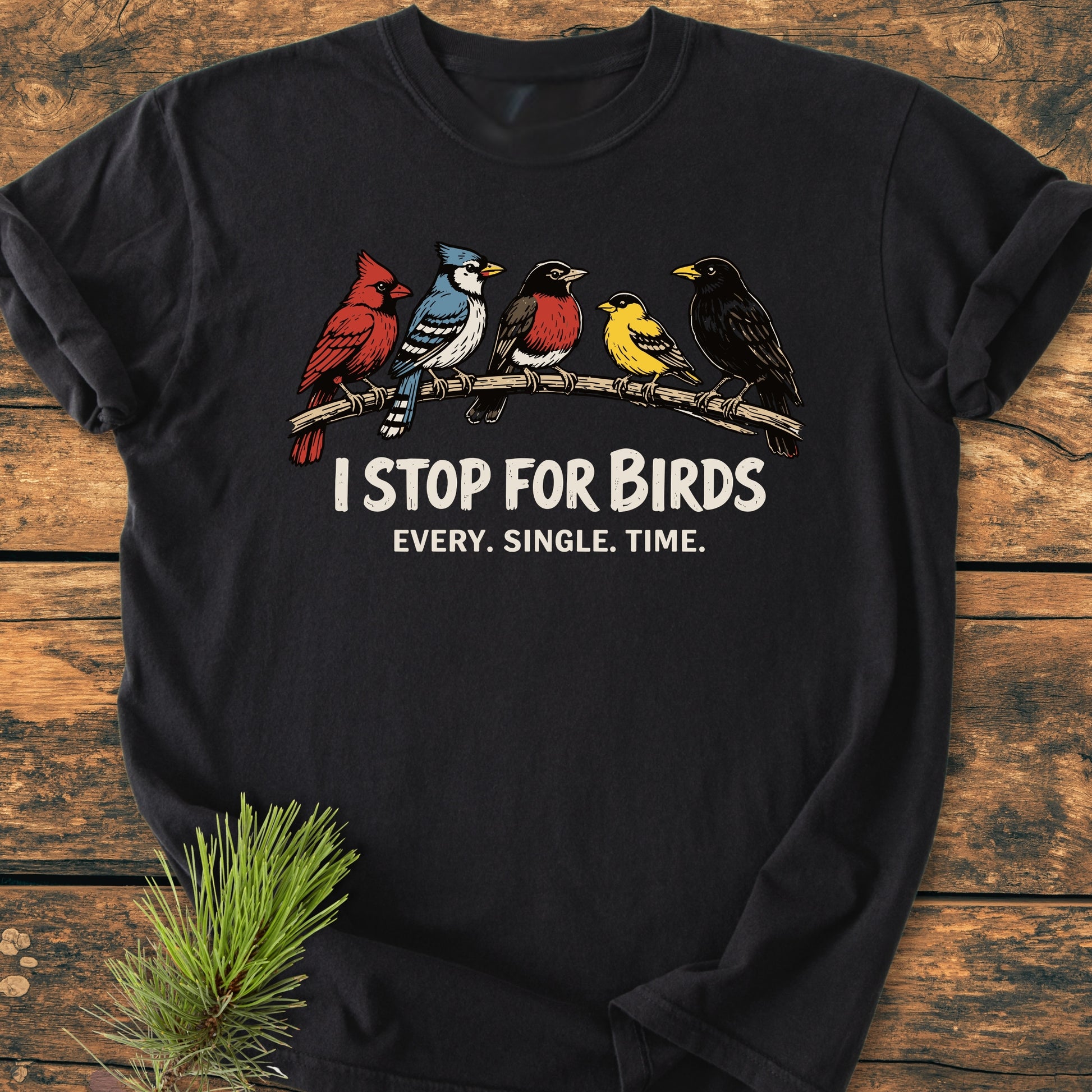 I Stop For Birds - Vintage Wash Tee features songbirds on a branch with bold slogan, laid on rustic wood; soft-washed, durable, relaxed fit, showcasing customizable Comfort Colors garment-dyed design.