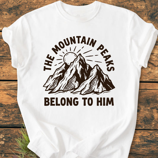 The Mountain Peaks Belong To Him - Vintage Wash Tee features a brown-ink mountain illustration with a sun, surrounded by bold text, on a laid-flat white T-shirt, highlighting its relaxed fit and durability.
