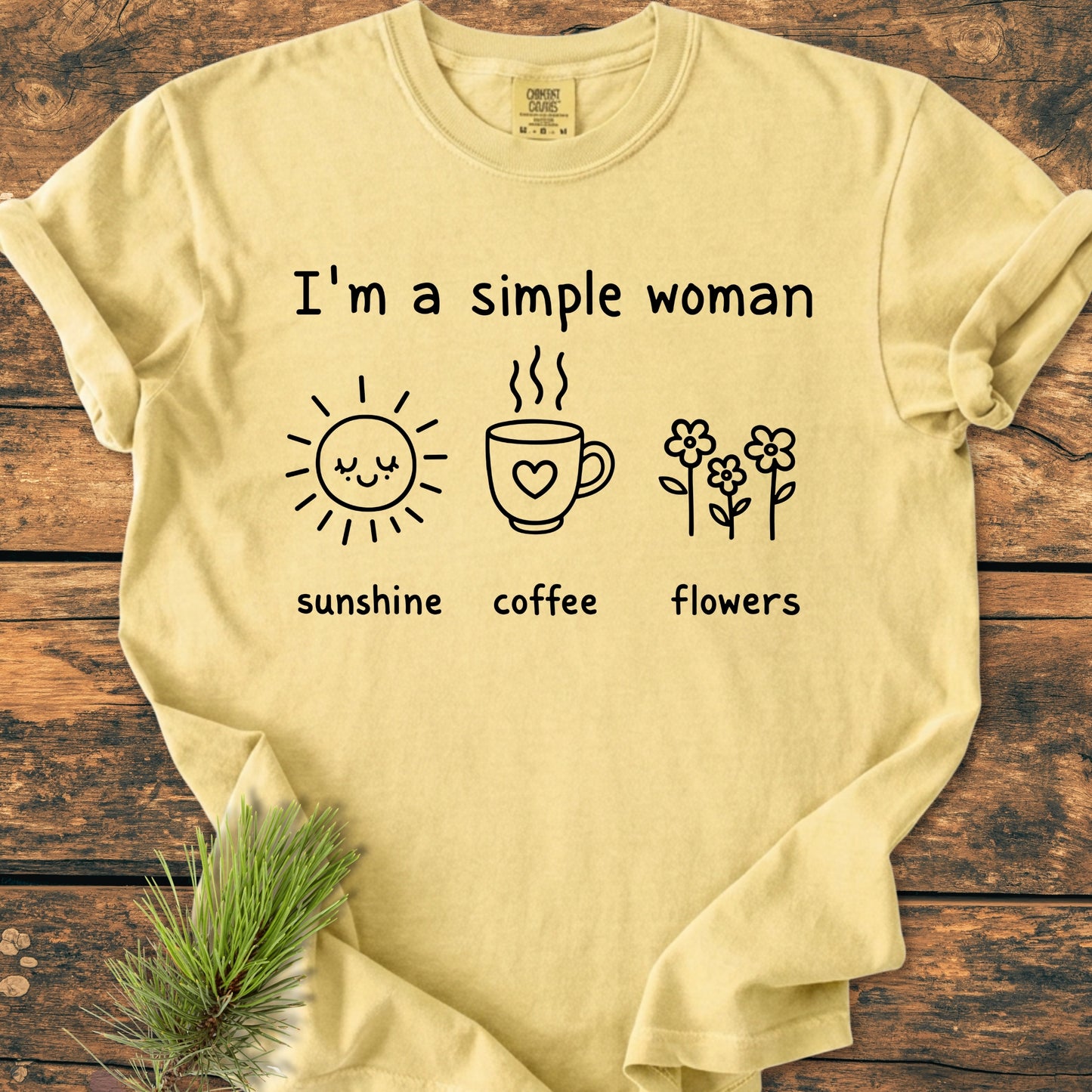 I'm A Simple Woman. Sunshine Coffee Flowers - Vintage Wash Tee featuring a pale-yellow T-shirt with icons of a sun, mug, and flowers on a wooden surface, showcasing its relaxed, garment-dyed design.